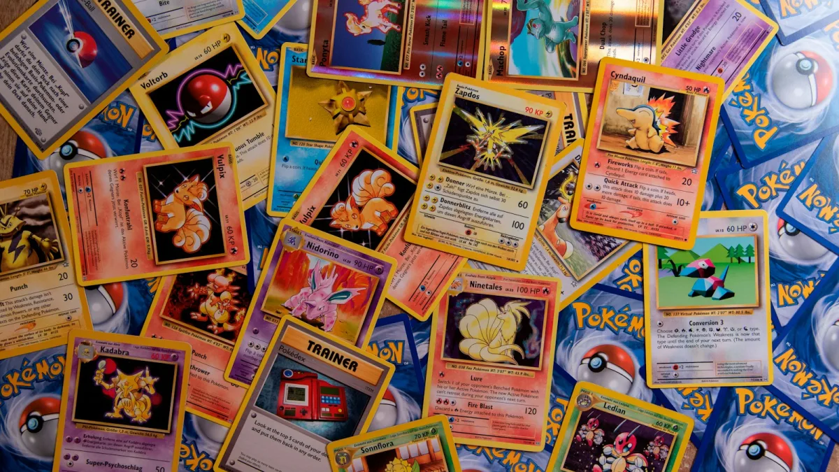 A collection of colorful Pokemon trading cards scattered across a flat surface